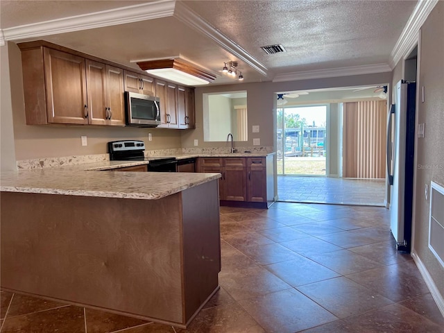 13637 Lagoon Dr, Hudson, FL 34667 - kitchen featuring a textured ceiling, visible vents, appliances with stainless steel finishes, a sink, and a peninsula