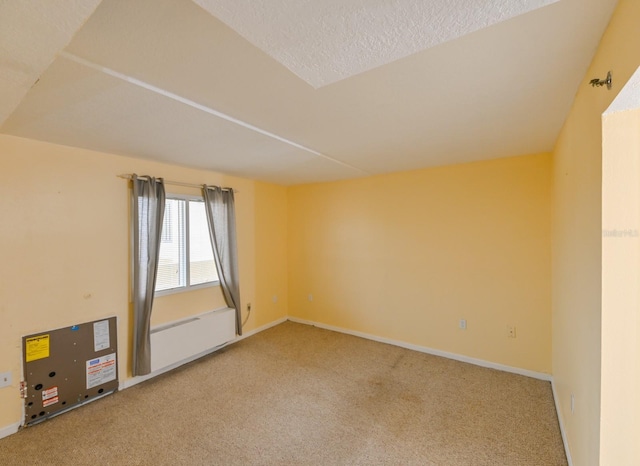 spare room featuring carpet floors and a textured ceiling