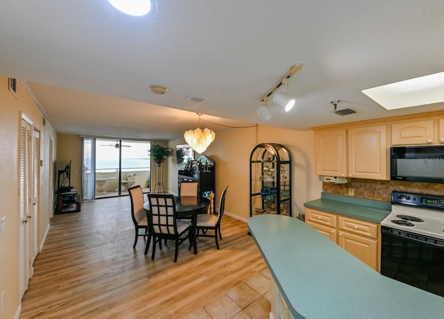 kitchen with electric stove, rail lighting, light brown cabinetry, and decorative backsplash