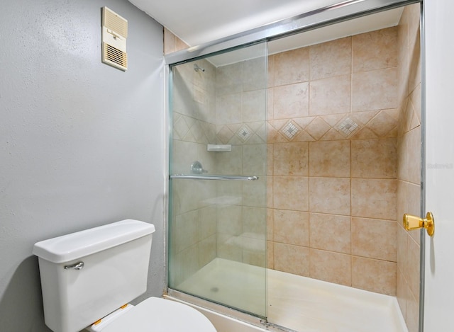 bathroom with a shower with door and toilet