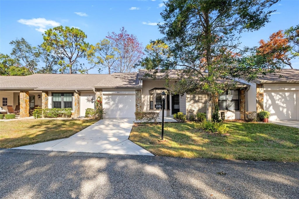 ranch-style house featuring a garage and a front lawn