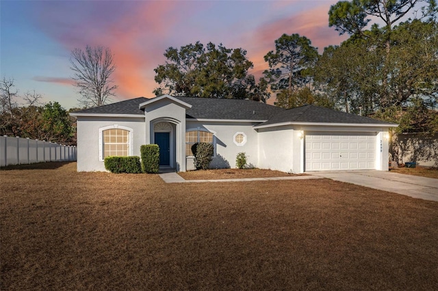 single story home featuring a garage and a yard