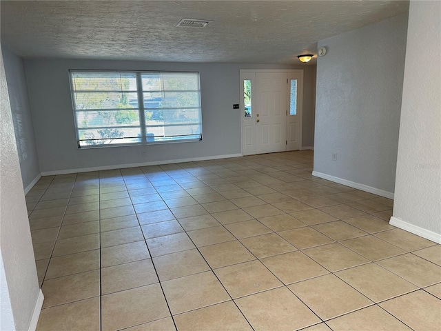 tiled entryway featuring a textured ceiling