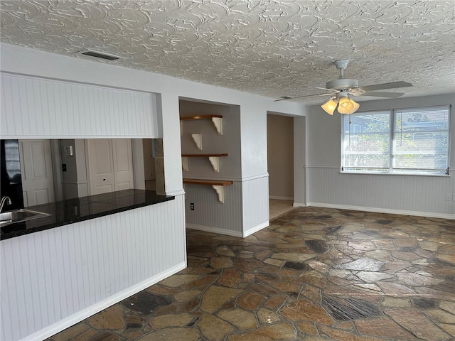 kitchen featuring sink, a textured ceiling, and ceiling fan