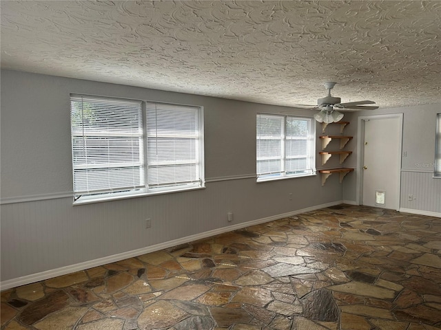 unfurnished room featuring ceiling fan and a textured ceiling