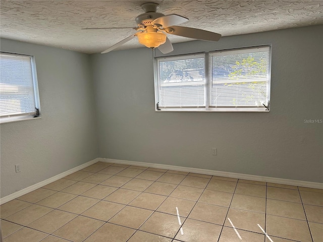 spare room featuring light tile patterned floors, a textured ceiling, and ceiling fan