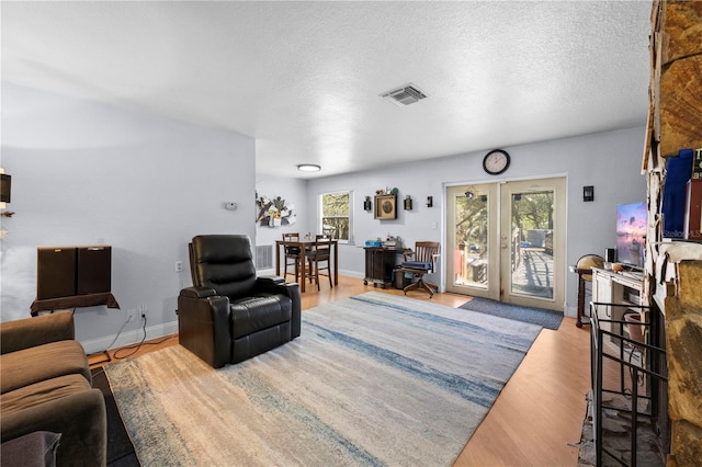 living room featuring hardwood / wood-style floors, a wealth of natural light, and french doors