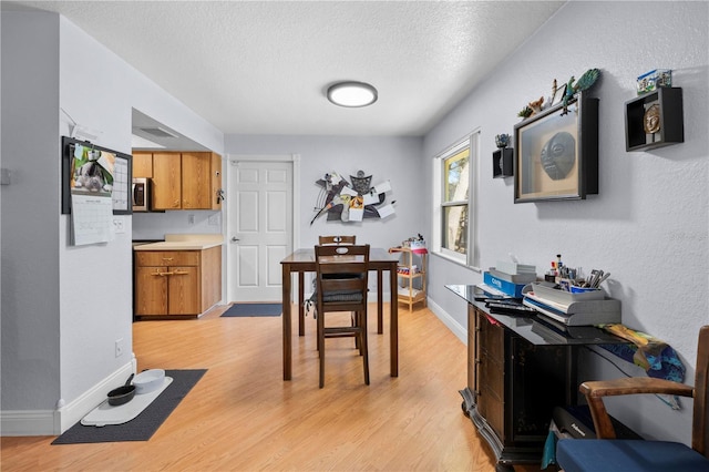 interior space featuring a textured ceiling and light hardwood / wood-style flooring