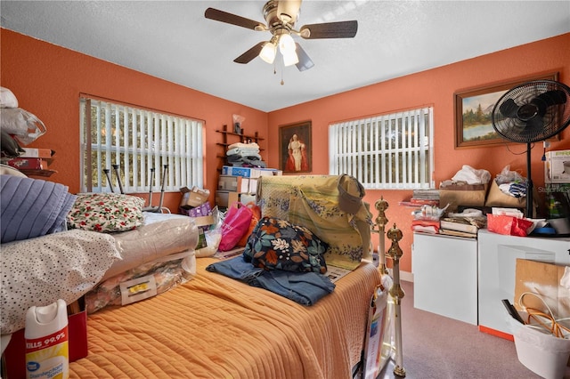 carpeted bedroom featuring ceiling fan and a textured ceiling