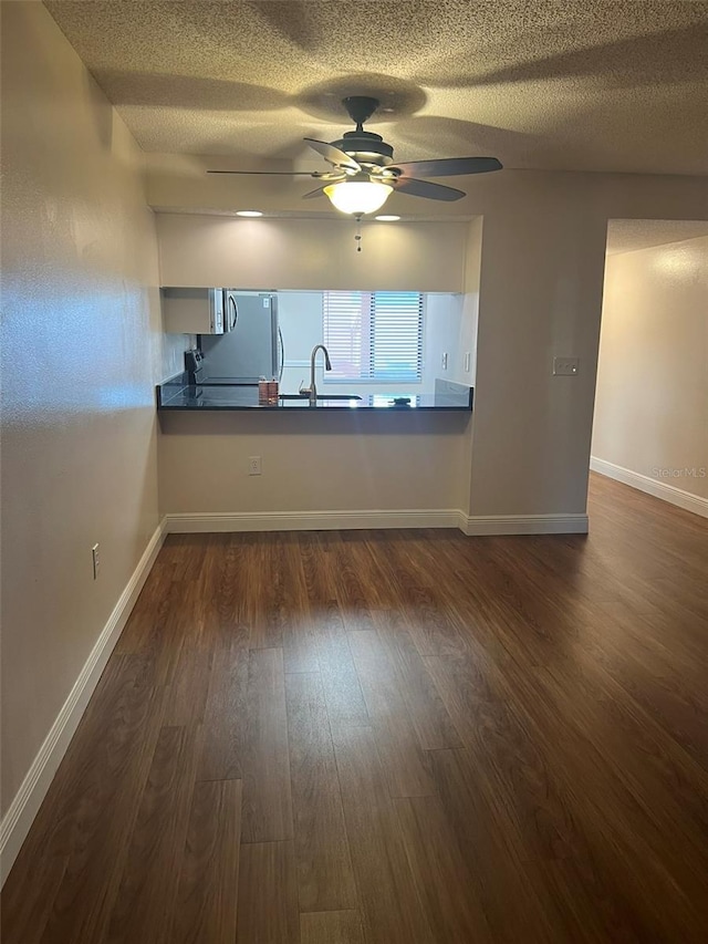 empty room with sink, dark hardwood / wood-style floors, and ceiling fan