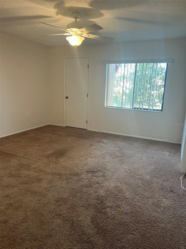 spare room with ceiling fan, carpet flooring, and a textured ceiling