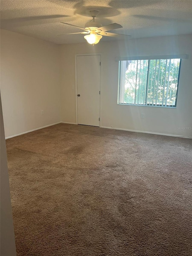 spare room featuring ceiling fan, carpet floors, and a textured ceiling