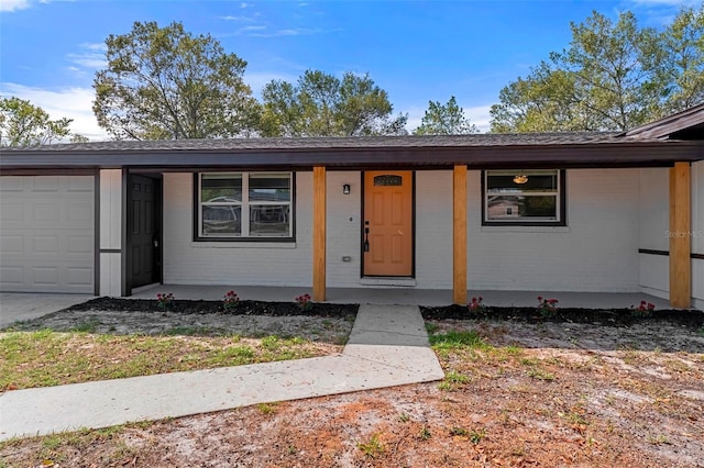 ranch-style home with covered porch and a garage