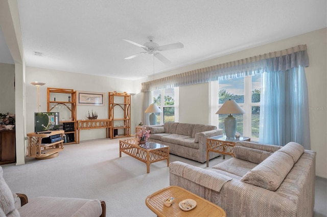 carpeted living room with ceiling fan