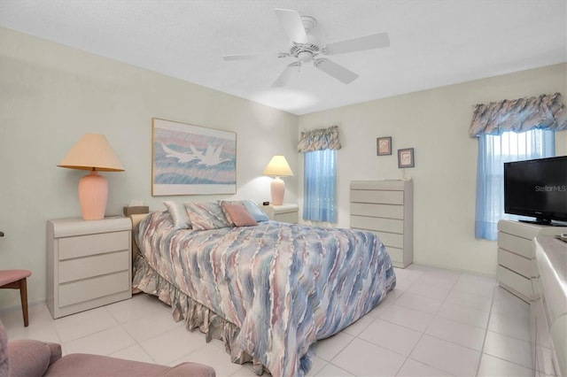 tiled bedroom with ceiling fan and a textured ceiling