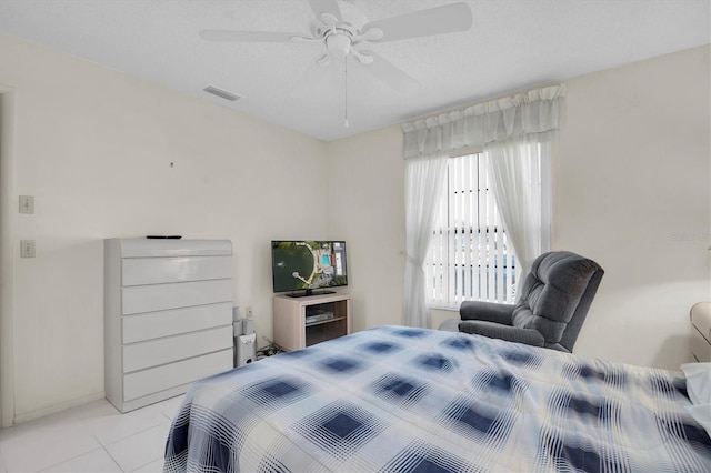 tiled bedroom featuring a textured ceiling and ceiling fan