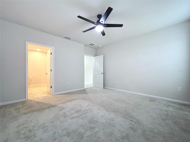 unfurnished bedroom featuring ceiling fan, ensuite bathroom, and light carpet