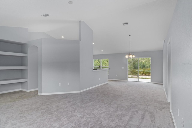 unfurnished living room featuring built in shelves, light colored carpet, vaulted ceiling, and a notable chandelier