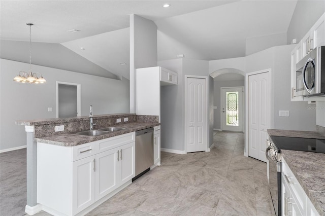 kitchen featuring vaulted ceiling, appliances with stainless steel finishes, sink, white cabinets, and hanging light fixtures