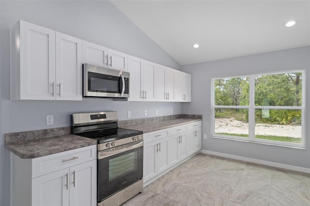 kitchen featuring white cabinetry, lofted ceiling, and appliances with stainless steel finishes