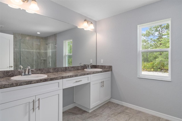 bathroom featuring a shower with door, vanity, and a wealth of natural light