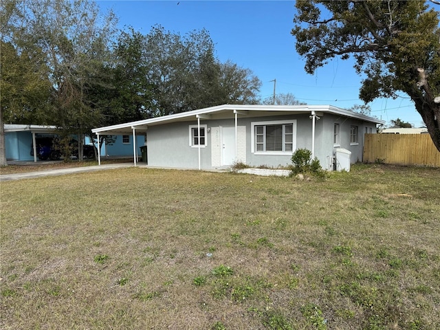 ranch-style house featuring a carport and a front lawn