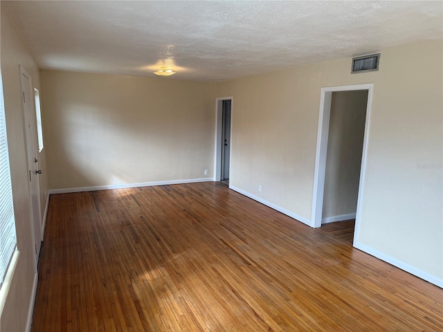 unfurnished room featuring hardwood / wood-style flooring and a textured ceiling