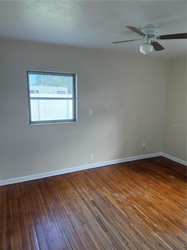 spare room with hardwood / wood-style flooring and ceiling fan