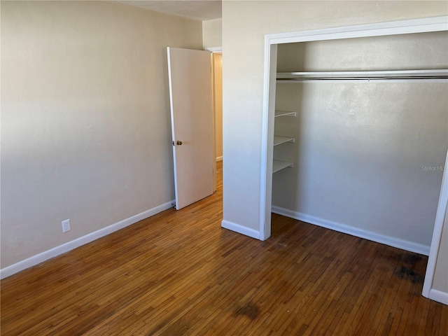 unfurnished bedroom with hardwood / wood-style flooring and a closet