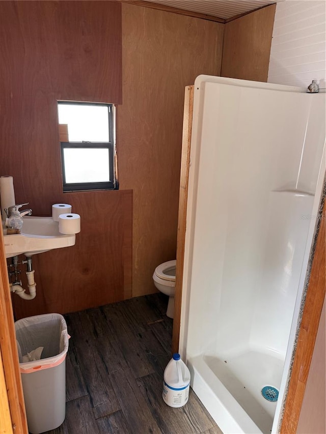 bathroom featuring sink, hardwood / wood-style flooring, toilet, and a shower