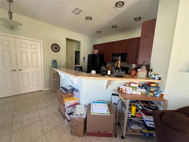 kitchen featuring light tile patterned floors, a kitchen breakfast bar, kitchen peninsula, decorative backsplash, and black appliances