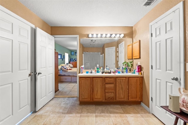 bathroom featuring vanity, tile patterned floors, and a textured ceiling