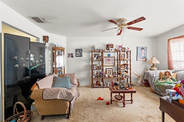 carpeted living room with ceiling fan and a textured ceiling