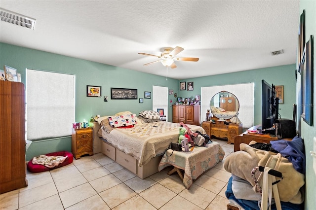 bedroom featuring light tile patterned floors, a textured ceiling, and ceiling fan