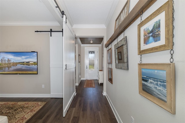 corridor featuring dark hardwood / wood-style floors, ornamental molding, and a barn door