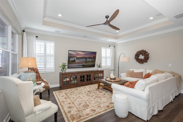 living room featuring ceiling fan, ornamental molding, a tray ceiling, and dark hardwood / wood-style flooring