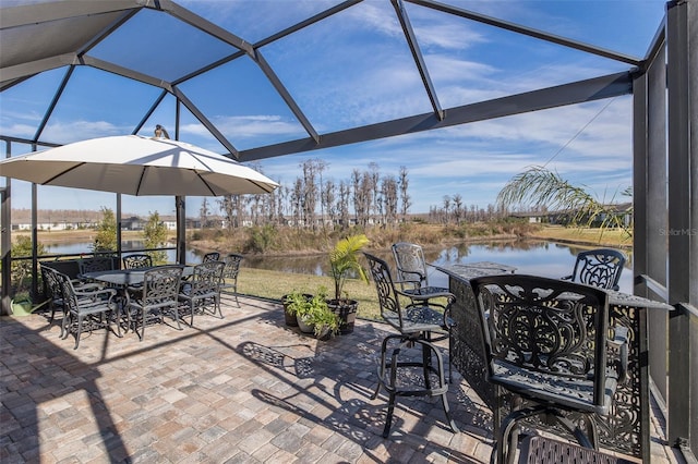 view of patio with a water view and glass enclosure