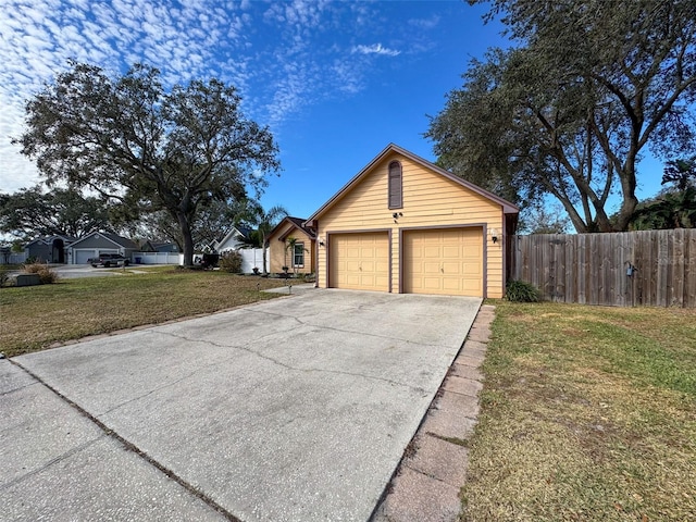 exterior space with an attached garage, driveway, a front lawn, and fence