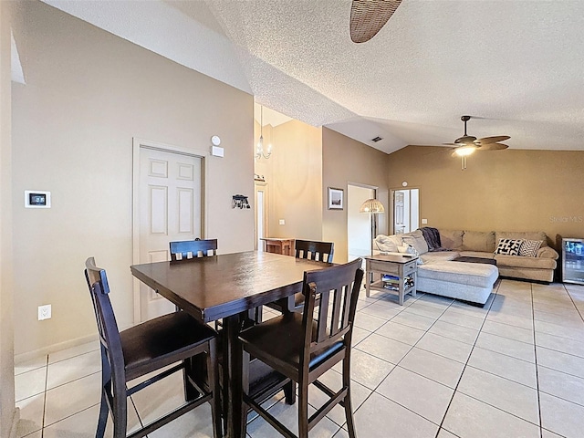 dining space featuring visible vents, vaulted ceiling, light tile patterned floors, ceiling fan with notable chandelier, and a textured ceiling