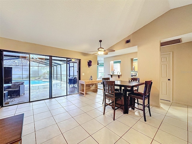 dining space with visible vents, a ceiling fan, a textured ceiling, light tile patterned flooring, and lofted ceiling