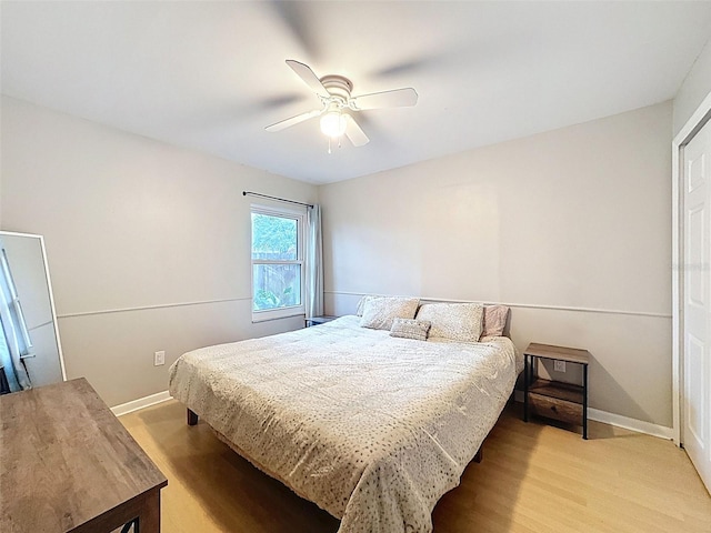 bedroom with baseboards, light wood-type flooring, and ceiling fan