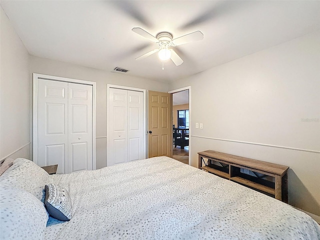 bedroom featuring visible vents, two closets, and a ceiling fan