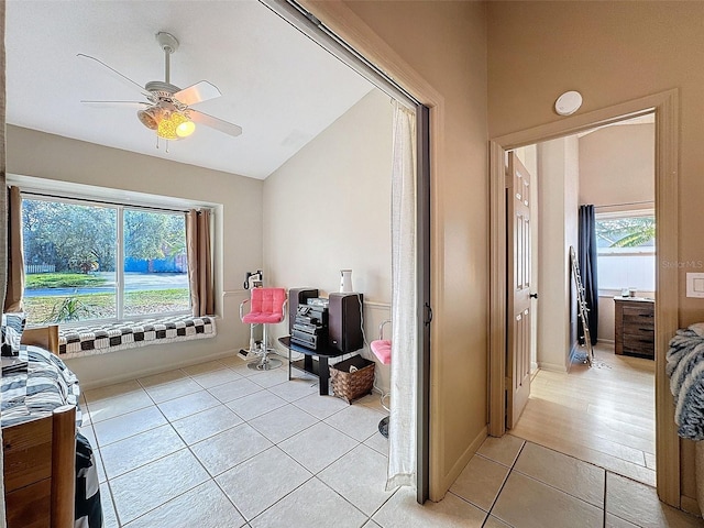 interior space featuring light tile patterned floors, baseboards, lofted ceiling, and ceiling fan