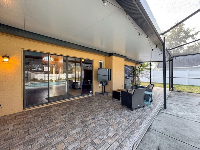 view of patio featuring glass enclosure and fence