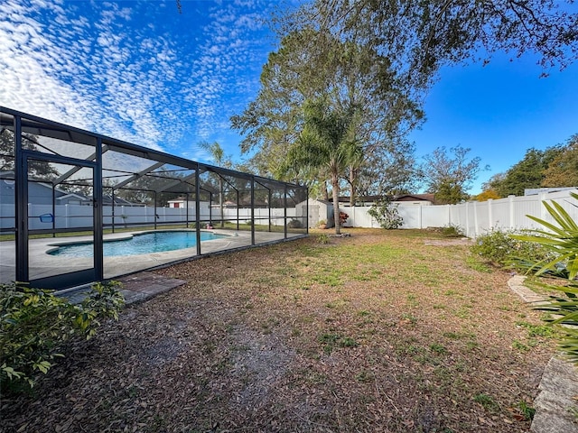 view of yard with glass enclosure, a fenced backyard, and a fenced in pool