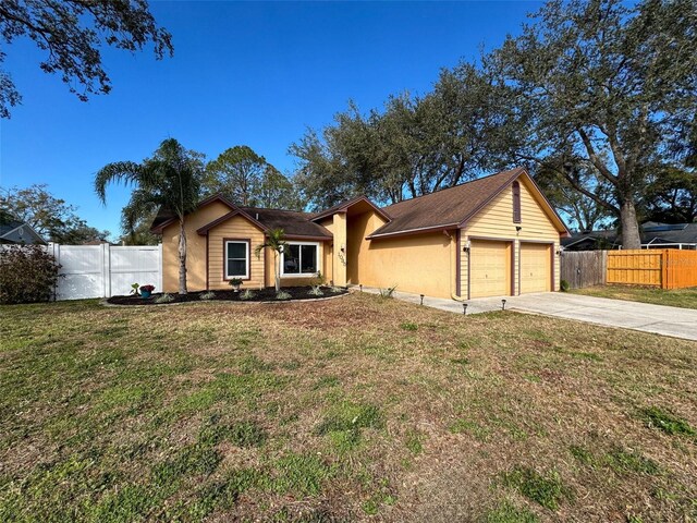 single story home featuring a front lawn, fence, and a garage