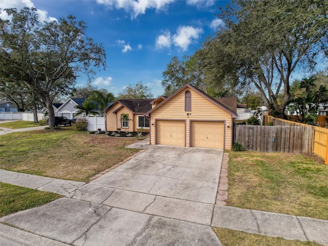 view of front of home featuring a garage, concrete driveway, a front lawn, and fence