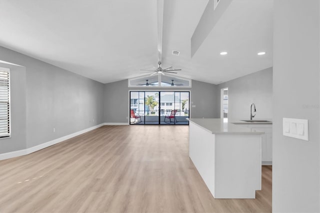 kitchen featuring lofted ceiling, sink, white cabinetry, light hardwood / wood-style flooring, and ceiling fan