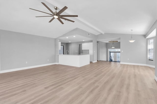 5925 Seaside Dr, New Port Richey, FL 34652 - unfurnished living room featuring ceiling fan, sink, light hardwood / wood-style floors, and vaulted ceiling with beams