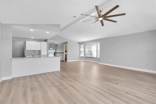 5925 Seaside Dr, New Port Richey, FL 34652 - unfurnished living room with vaulted ceiling, sink, ceiling fan, and light hardwood / wood-style floors